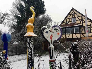Blick in den verschneiten Garten der vhs mit drei Skulpturen aus dem entsprechenden Kurs