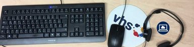 Sie sehen eine Tastatur, Computermouse und ein Headset