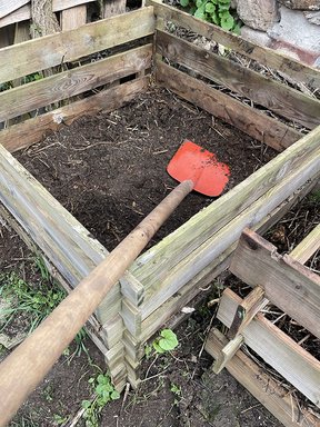 Rote Schaufel im Kompost